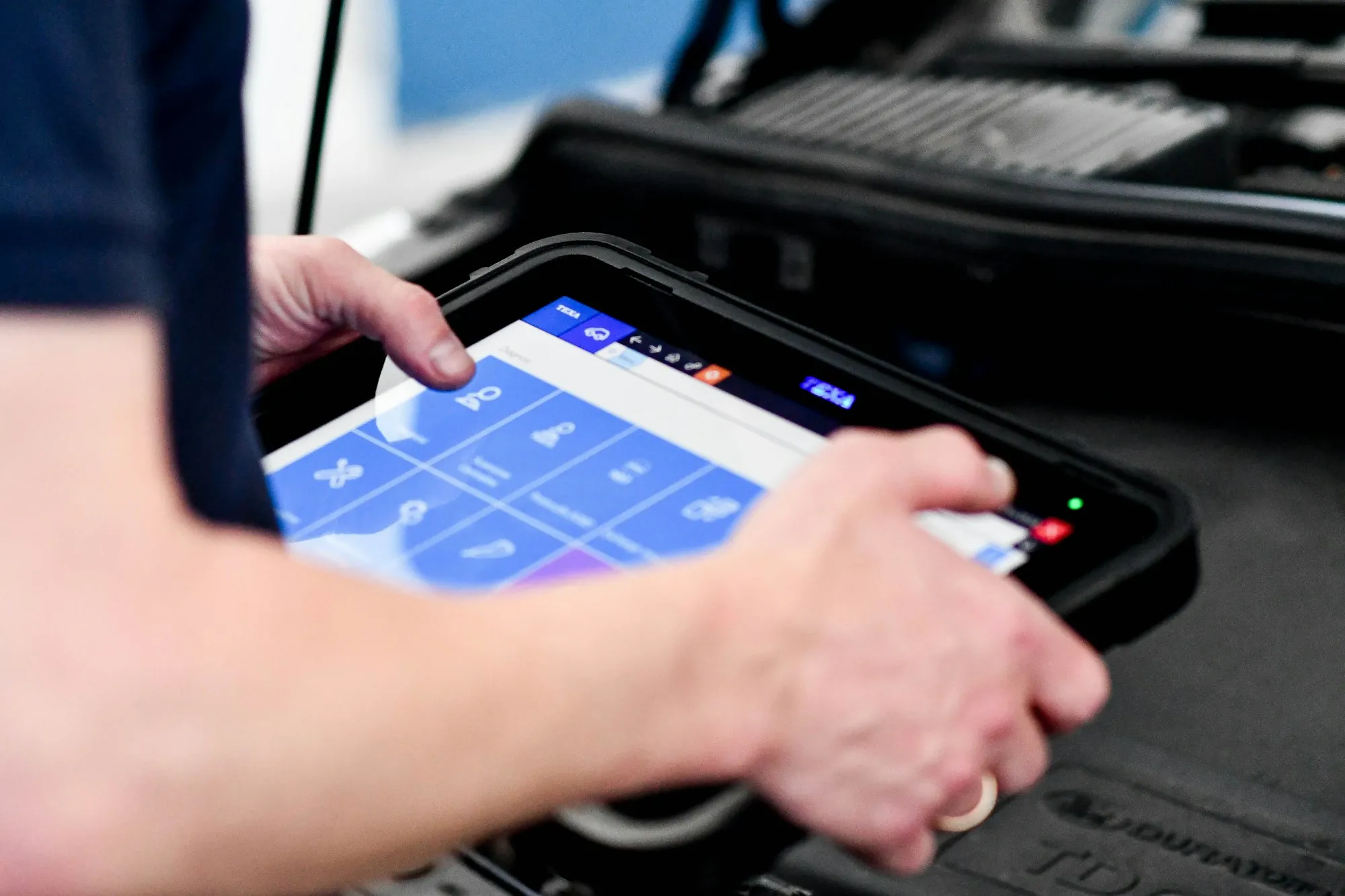Hand holding a diagnostic tablet with vehicle data