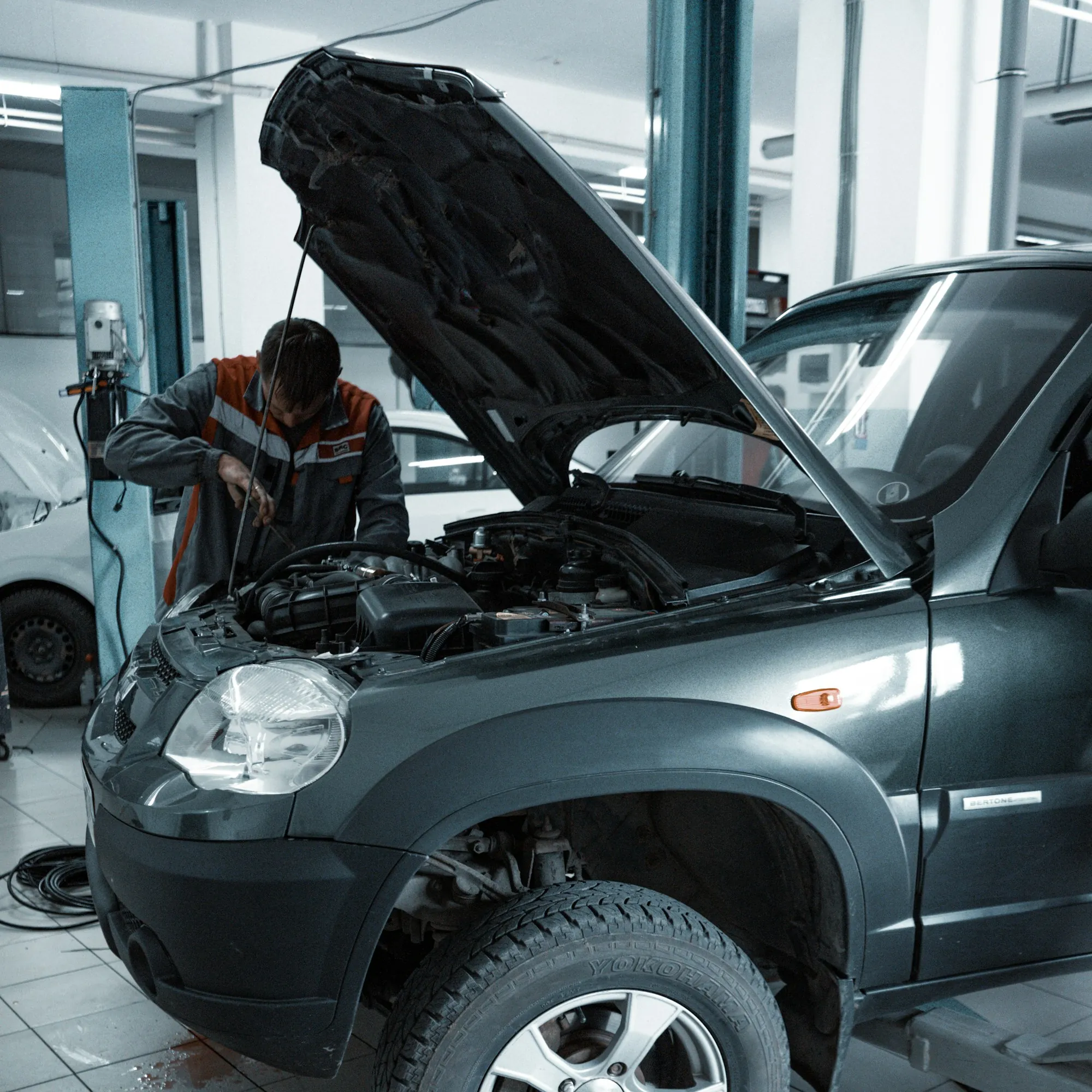 Car with its hood up in a repair bay